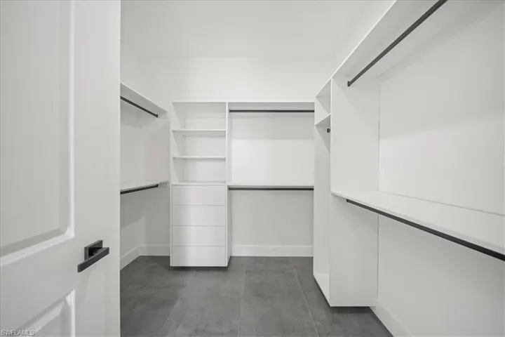 The expansive closet offers built-in shelving, drawer storage, and abundant hanging space, creating a clean and functional luxury wardrobe experience.