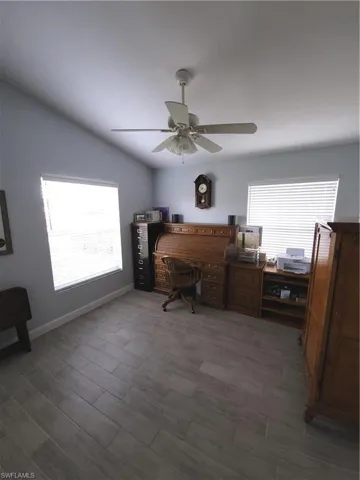 Office area featuring ceiling fan and light wood-style tile flooring