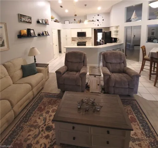 Family room with vaulted ceiling and light tile floors