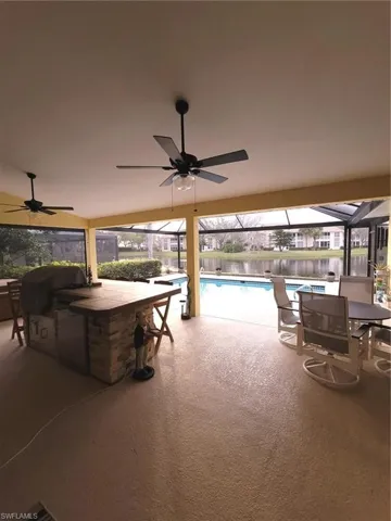 View of patio featuring a water view, ceiling fan, and outdoor kitchen