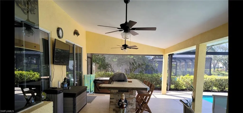 Extended lanai with vaulted ceiling and ceiling fans, outdoor kitchen, hot tub