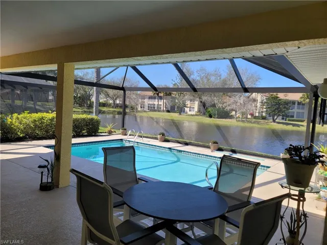 View of pool with a lanai, newly installed PANORAMIC view screen enclosure, a water view, and a patio area
