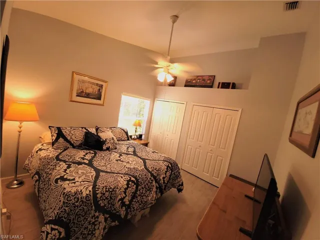 Bedroom with large closets, ceiling fan, and light wood-type tile flooring