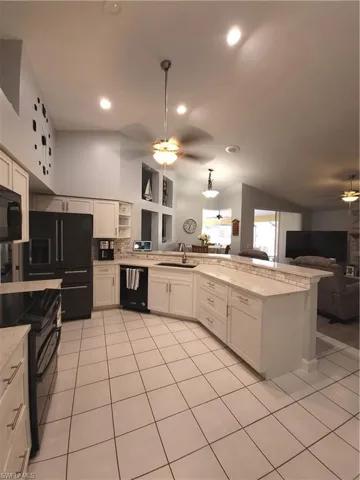 Kitchen featuring white cabinetry, dishwasher, sink, light stone countertops, and ceiling fan