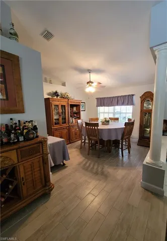 Formal Dining room with light tile floors, decorative columns, and ceiling fan