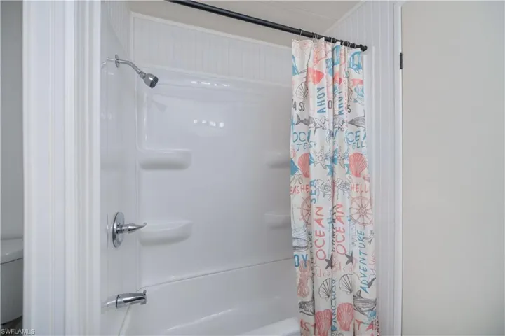 Bathroom featuring shower / bathtub combination with curtain