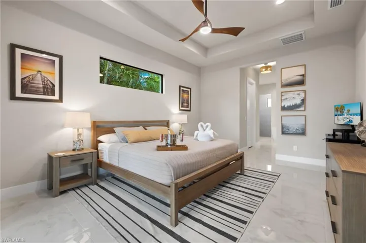 Bedroom featuring a tray ceiling and ceiling fan