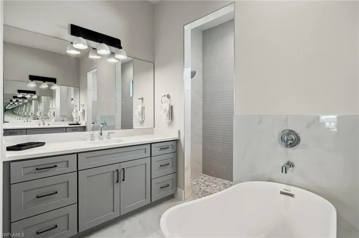 Bathroom with plus walk in shower, tile walls, and vanity