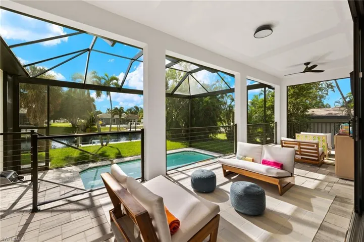 Sunroom / solarium with ceiling fan and a water view