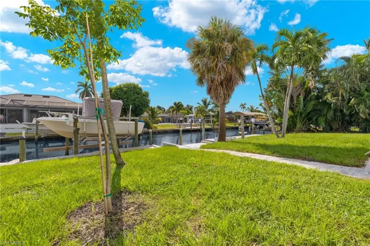 View of yard with a water view and a dock