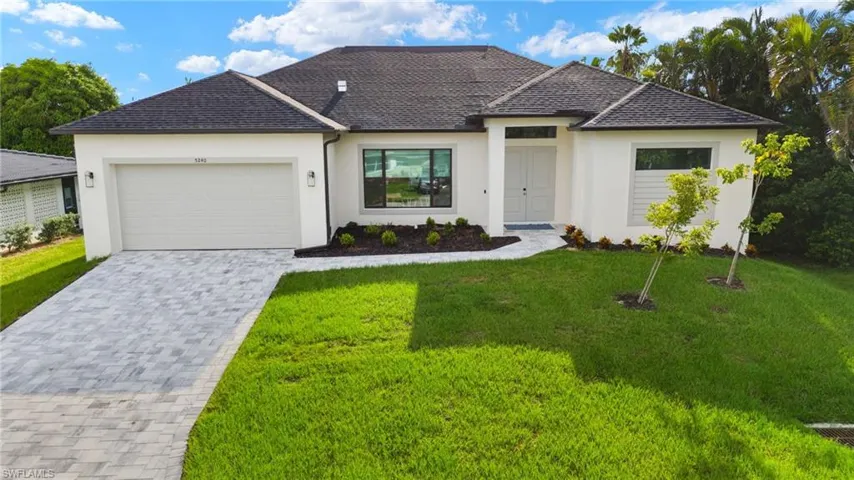 View of front of home with a garage and a front yard