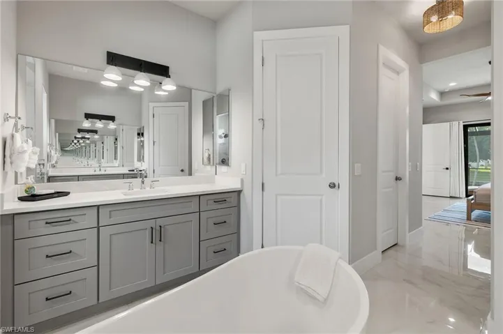 Bathroom featuring vanity, a tub, and ceiling fan