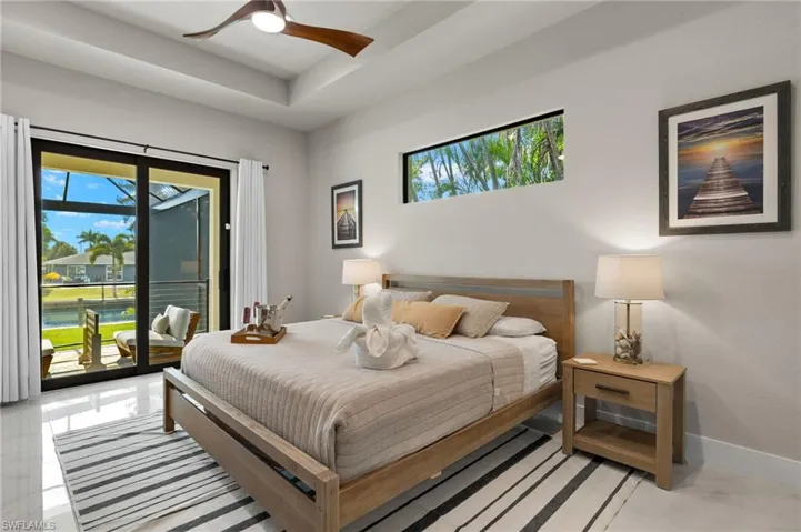 Bedroom with multiple windows, access to exterior, and ceiling fan