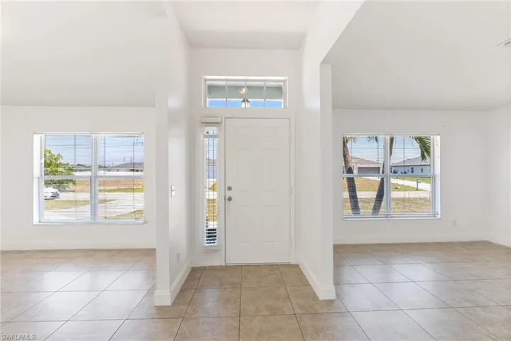 Living room on the Left-Entrance foyer featuring baseboards and light tile patterned floors