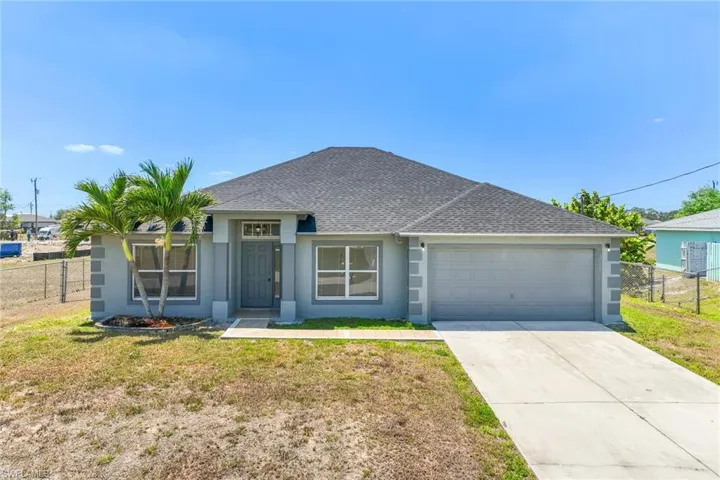 Ranch-style house featuring stucco siding, an attached garage, fence, and a shingled roof