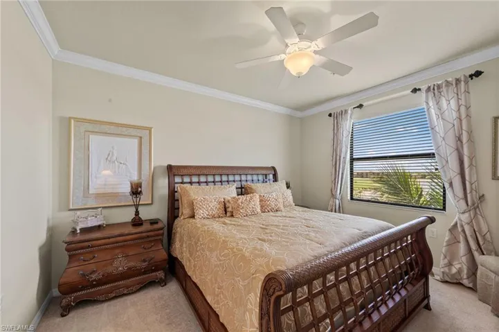 Room with crown molding, a ceiling fan with light fixture, carpeted flooring, and a window with horizontal blinds and drapery
