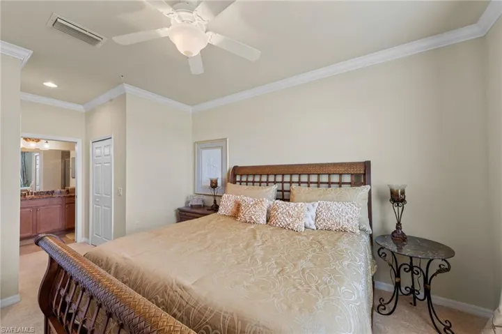 Neutral toned walls and carpeting, crown molding, and a ceiling fan with light fixture