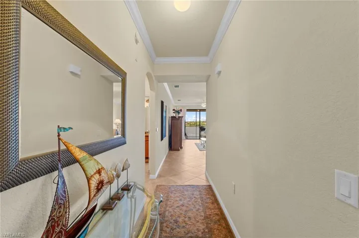 Hallway featuring neutral wall tones, crown molding, and recessed lighting