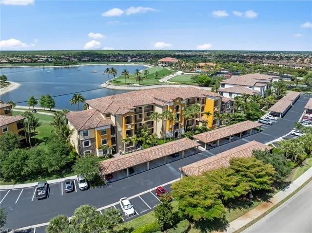 Multi-story residential building with stucco exterior and tile roofing, featuring multiple balconies