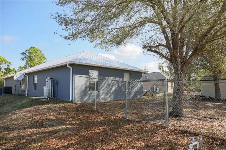 Back of house with stucco siding and a metal roof