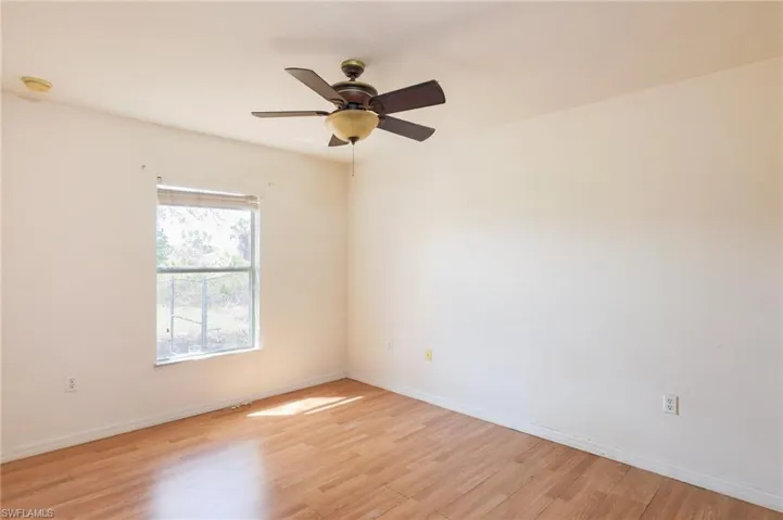 Empty room with light wood-style floors and a ceiling fan