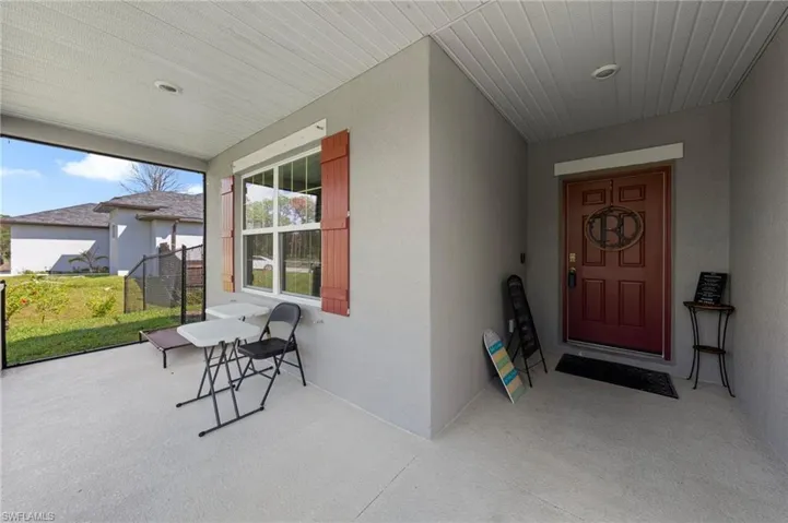 Property entrance featuring stucco siding and a porch