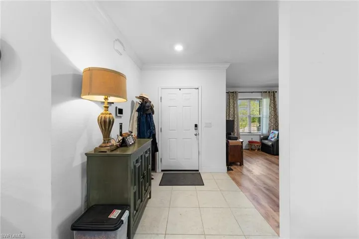 Foyer entrance featuring crown molding, light tile patterned floors, baseboards, and recessed lighting