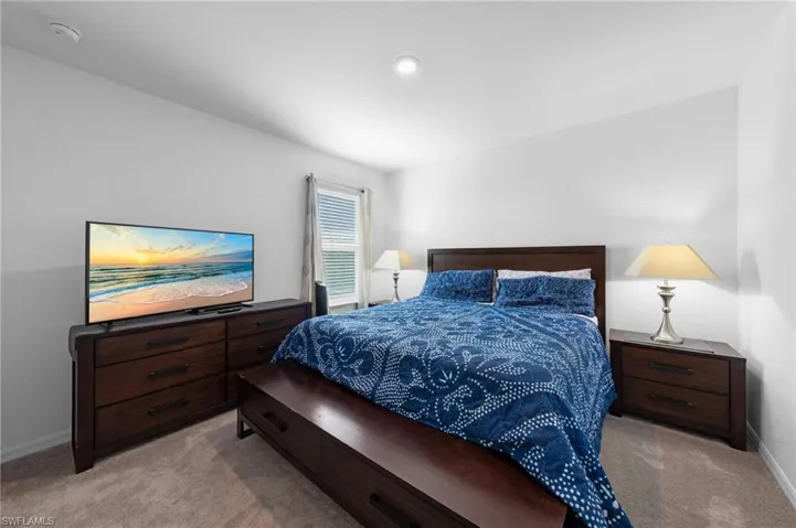 Bedroom featuring light colored carpet and baseboards