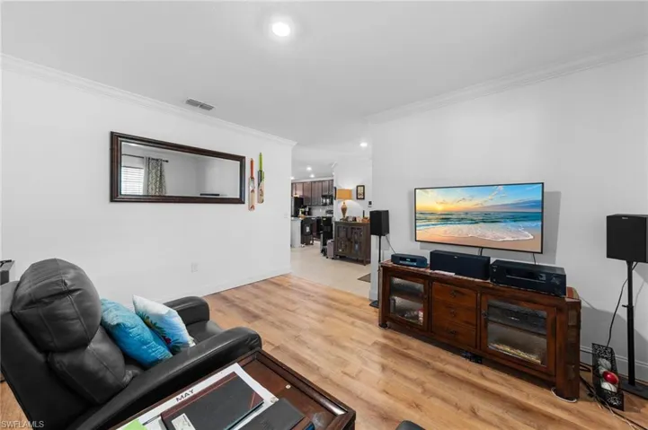 Living area featuring ornamental molding, recessed lighting, light wood finished floors, and baseboards