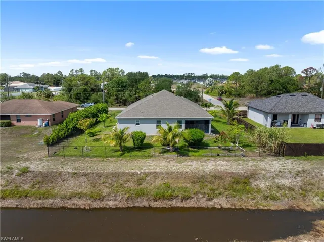 Aerial view of property and surrounding area with a nearby body of water
