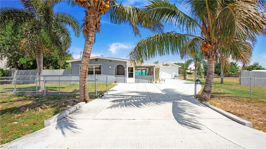View of front of property with a fenced front yard, concrete driveway, and a front yard