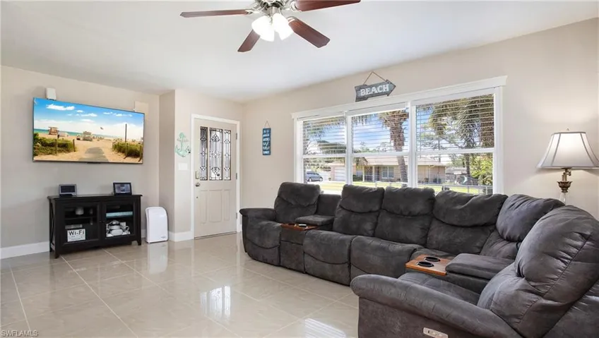 Living area featuring a ceiling fan and baseboards