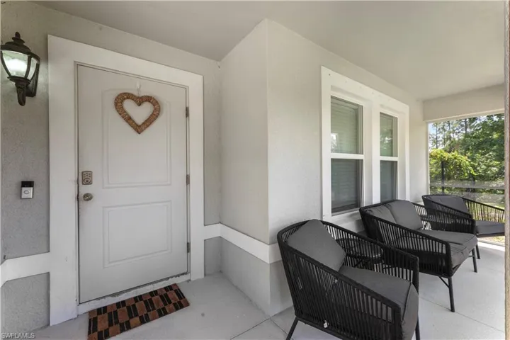 Doorway to property featuring covered porch