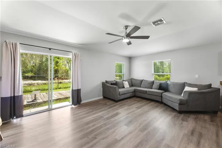 Living room featuring ceiling fan, wood-type flooring, and plenty of natural light