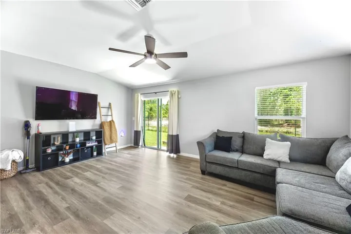 Living room with ceiling fan and hardwood / wood-style floors