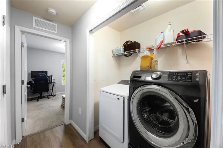 Laundry area with washing machine and dryer and hardwood / wood-style floors