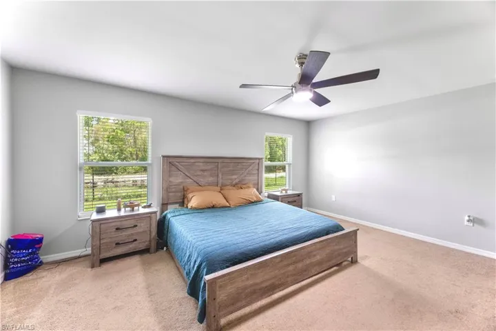 Bedroom featuring light colored carpet and ceiling fan
