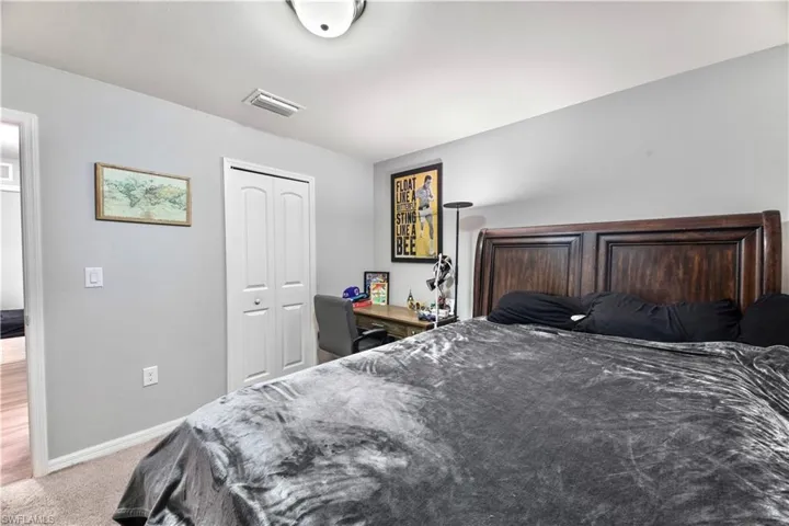 Carpeted bedroom with a closet