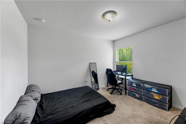 Bedroom featuring light carpet