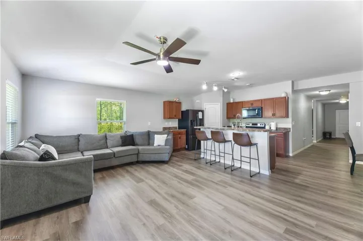 Living room featuring a healthy amount of sunlight, light hardwood / wood-style flooring, and ceiling fan