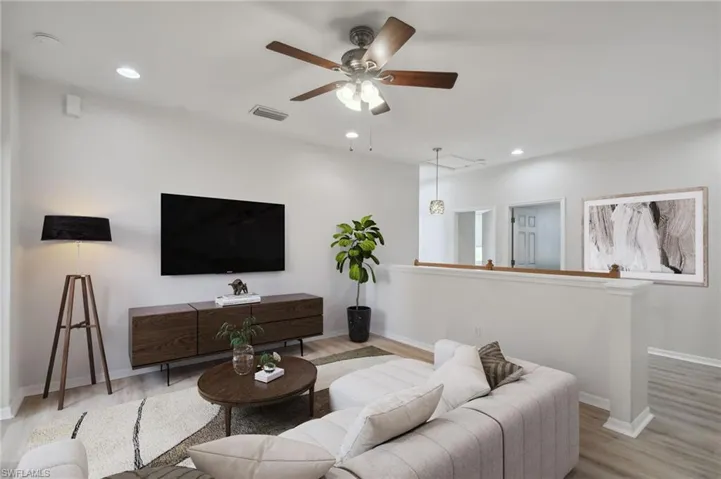 Living room with ceiling fan and light wood-type flooring