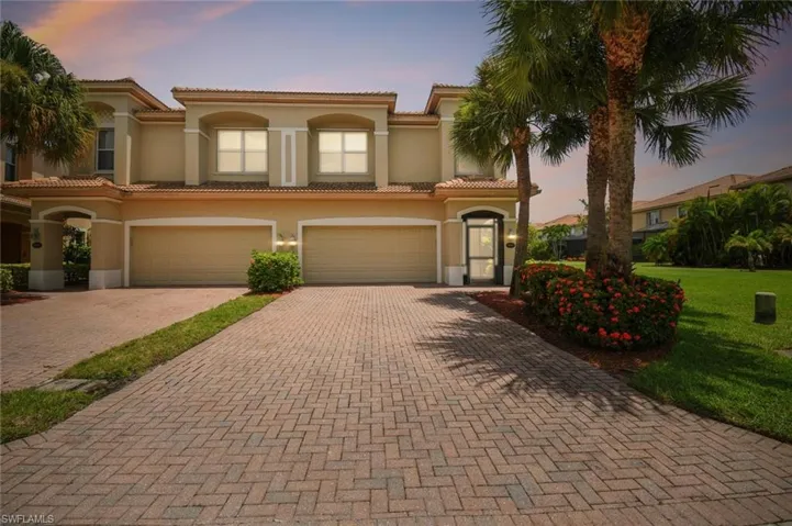 Mediterranean / spanish-style home with a garage and a lawn