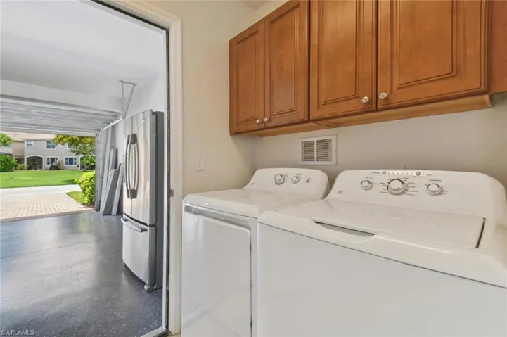 Laundry room featuring cabinets and washing machine and dryer