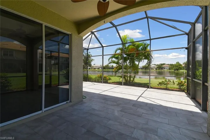 Unfurnished sunroom with plenty of natural light, a water view, and ceiling fan