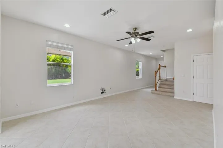 Empty room with light tile patterned flooring, ceiling fan, and plenty of natural light