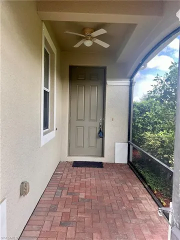 Doorway to property featuring ceiling fan