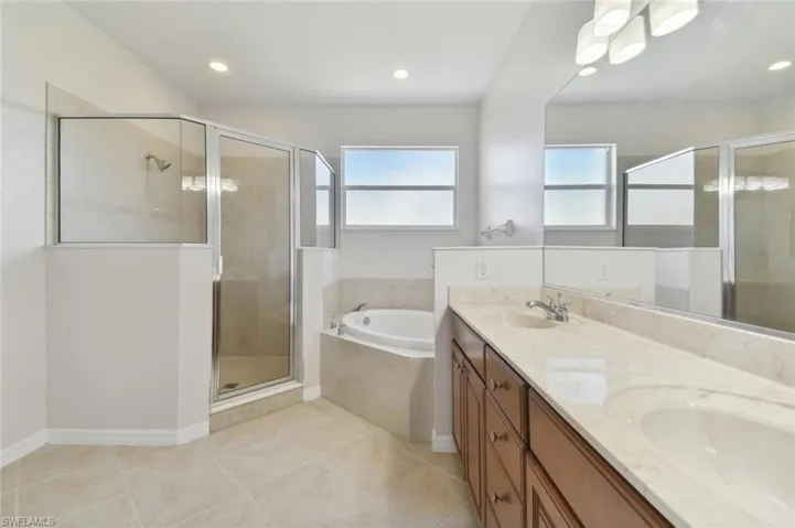 Bathroom featuring independent shower and bath, tile patterned flooring, and double vanity