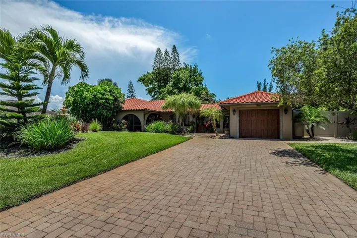 Mediterranean / spanish-style house featuring a garage and a front lawn