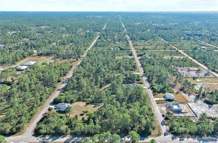 Aerial overview of property's location with a heavily wooded area