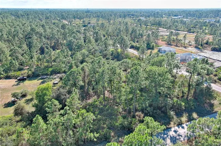 View of property location with a heavily wooded area